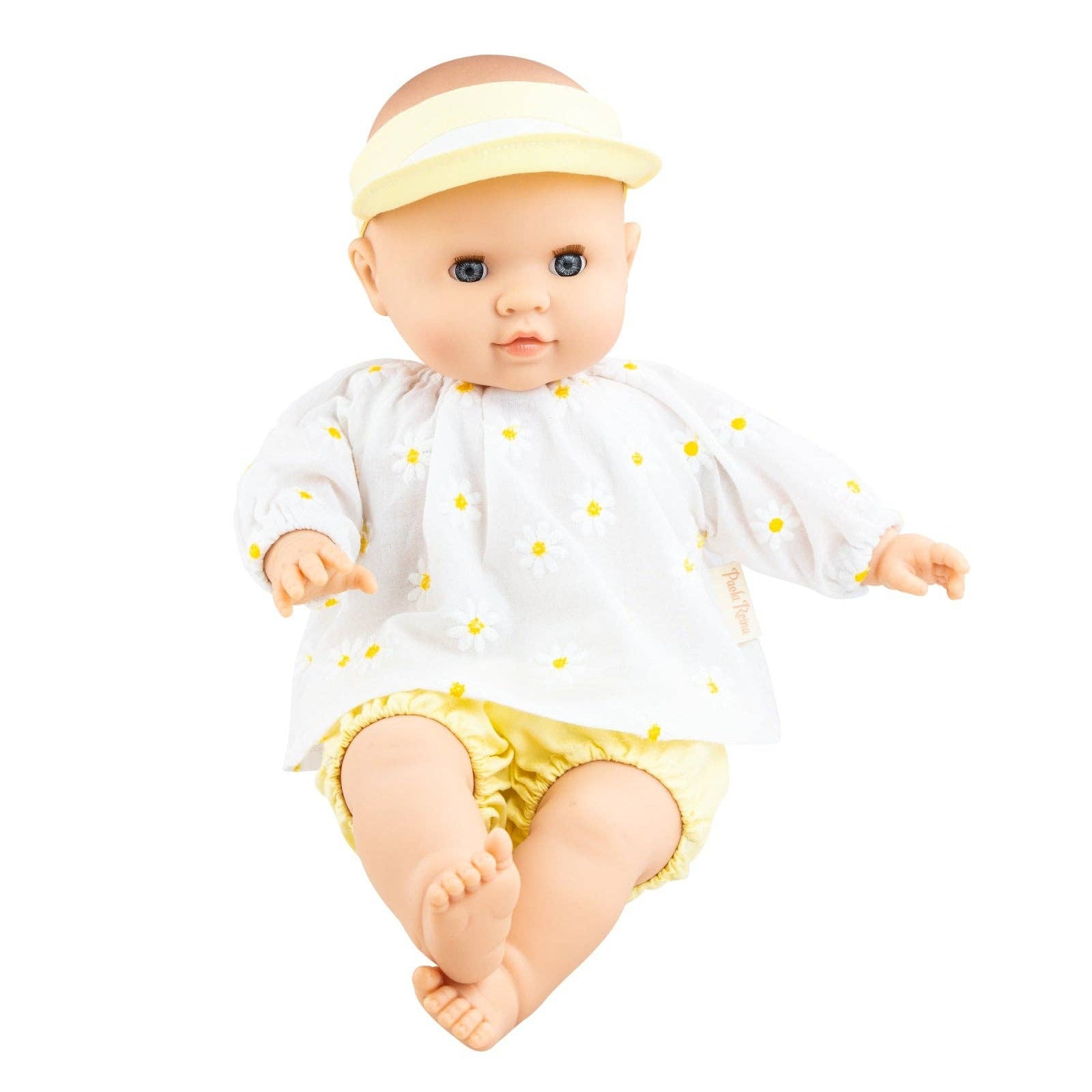 Baby doll wearing a white outfit with yellow polka dots and a yellow visor on a white background