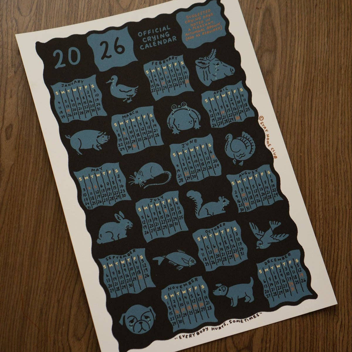 Calendar poster with animal illustrations on a wooden surface