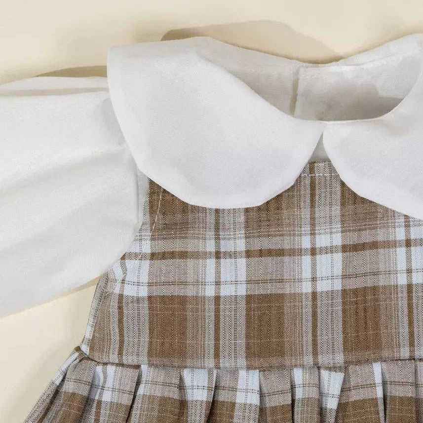 Plaid dress with a white collar on a beige background