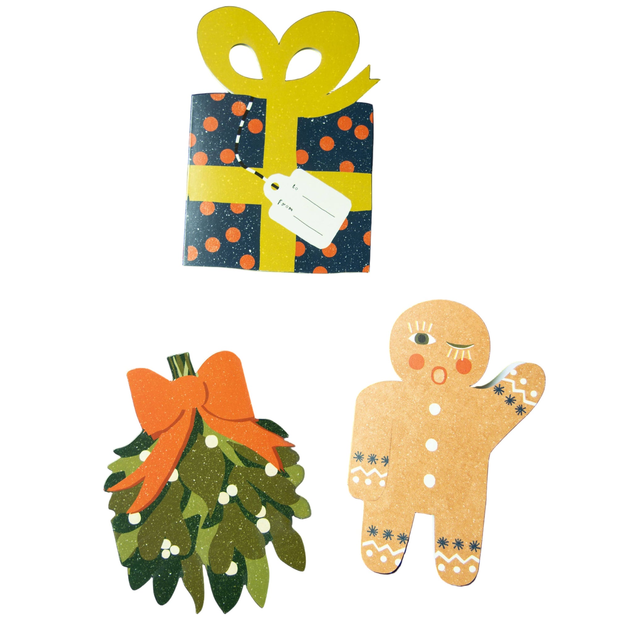 Decorative cutouts of a gift, gingerbread man, and wreath on a black background