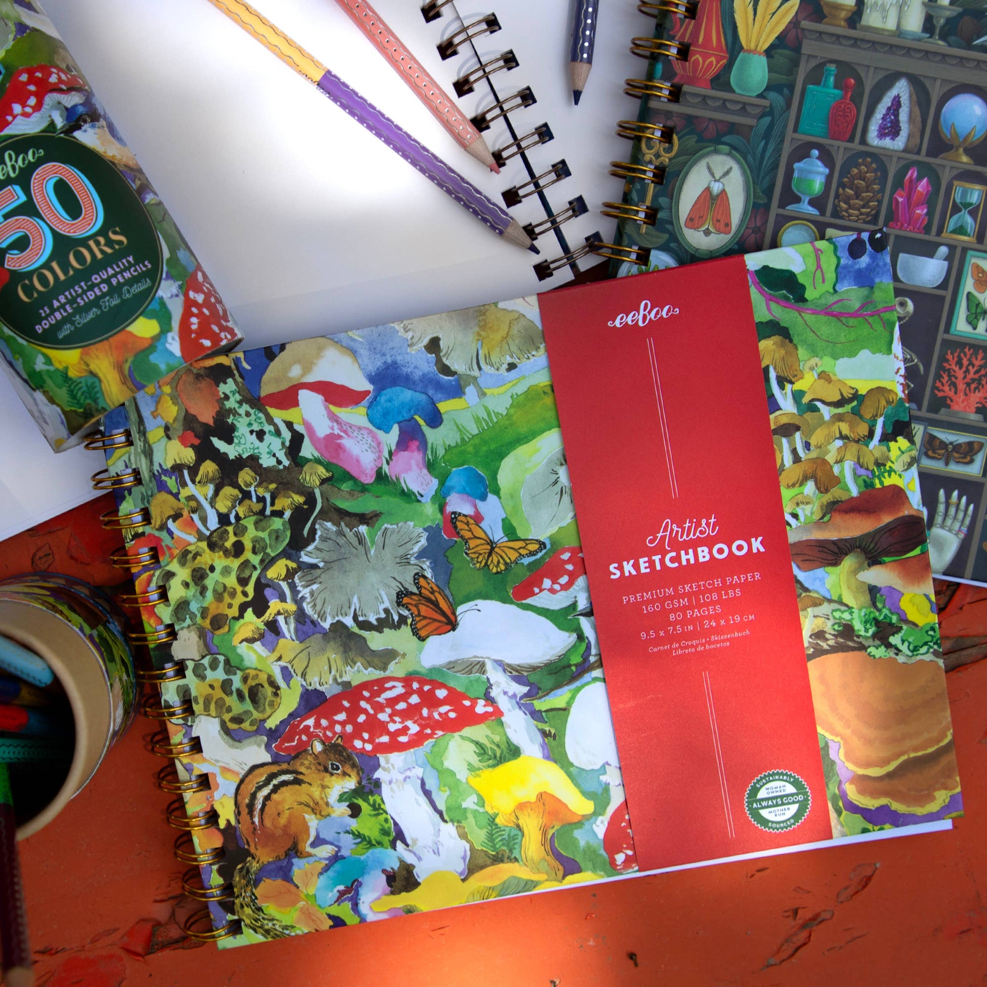 Colorful sketchbook with nature-themed design on a red surface