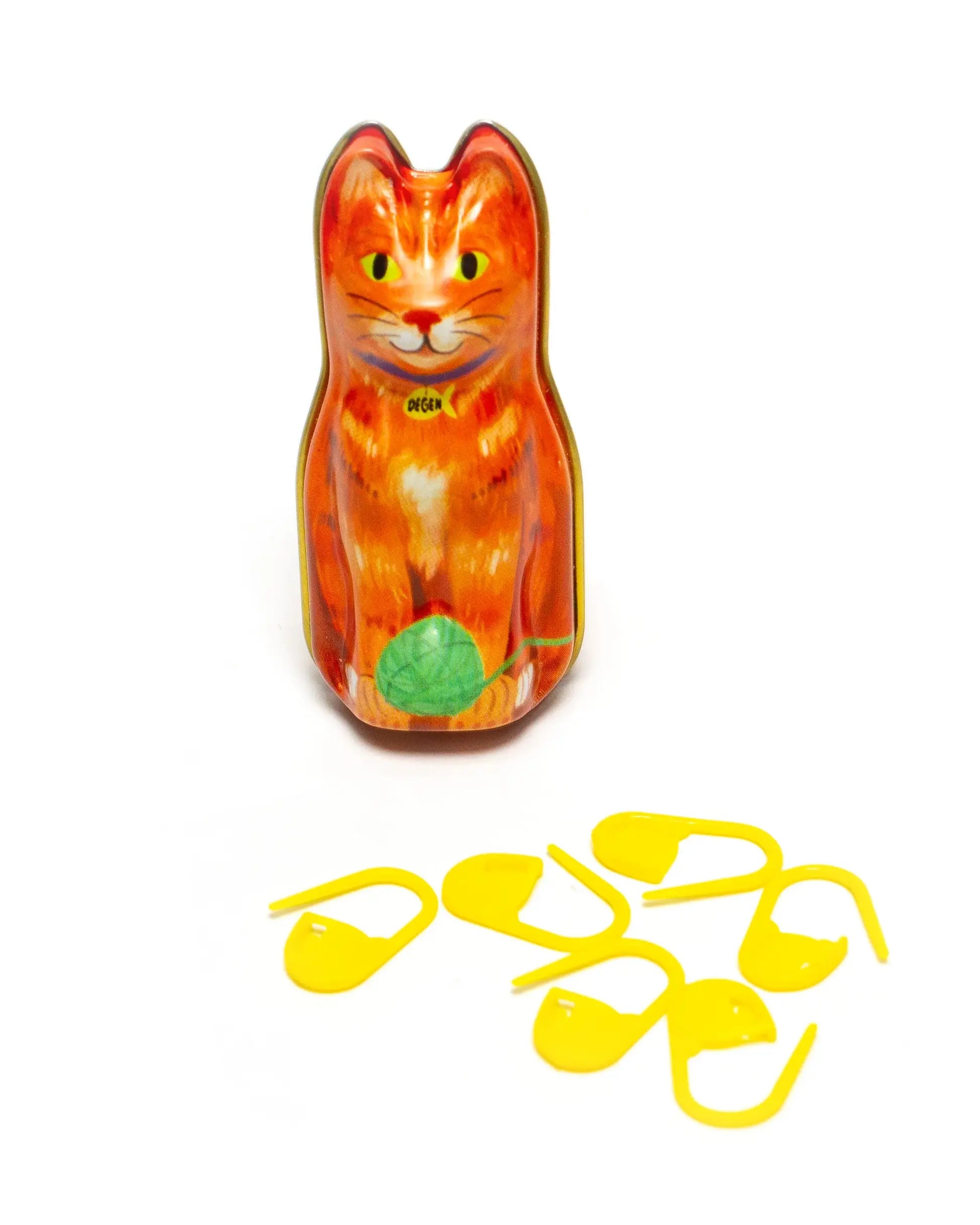 Cat-shaped container with a green leaf and yellow straws on a white background