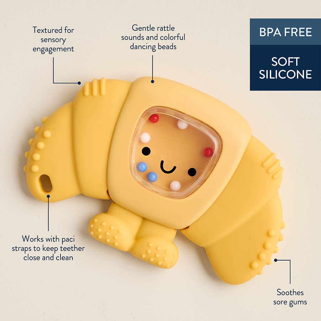 Yellow silicone pastry-shaped teether with text highlighting features on a beige background