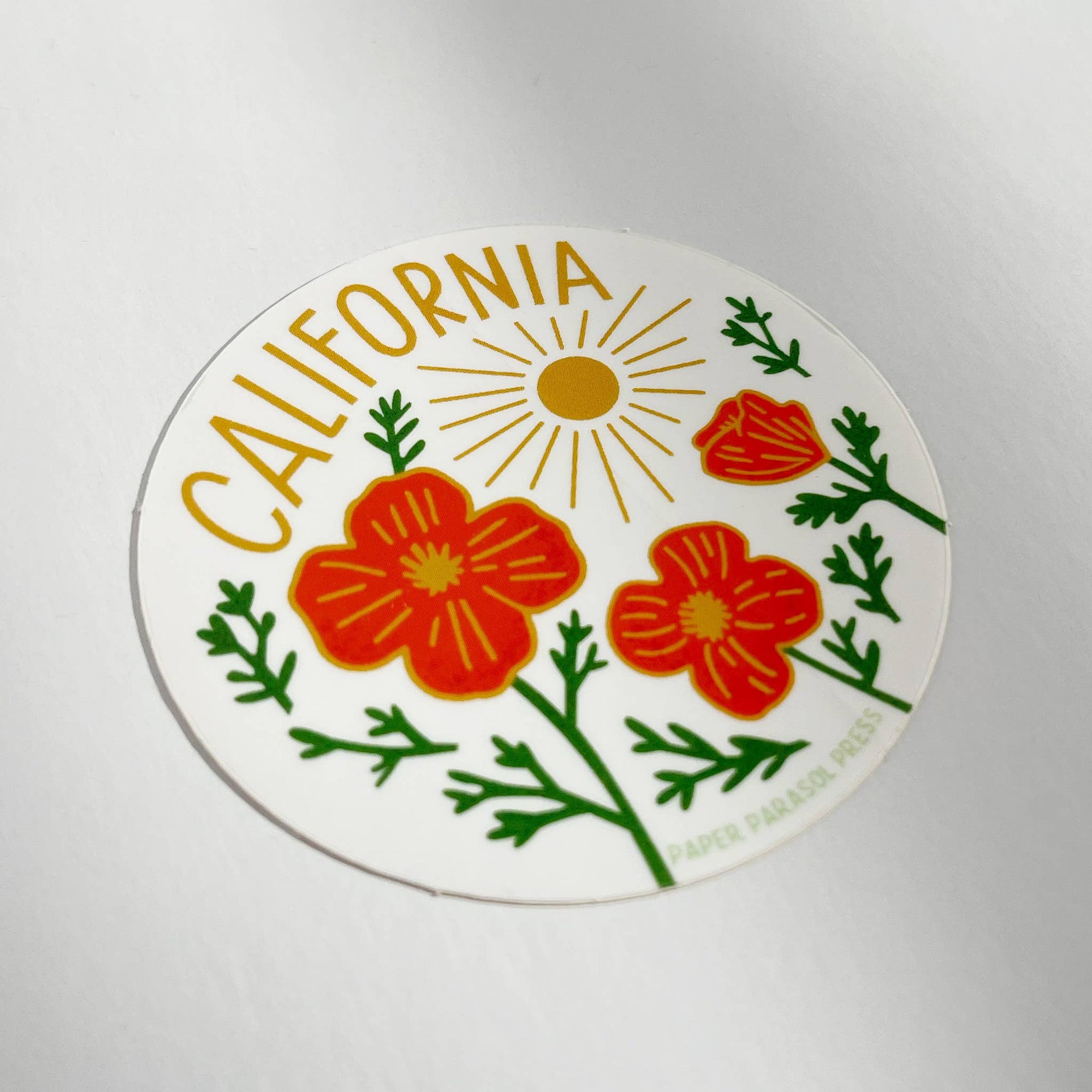 Round sticker with California text and floral design on a white background