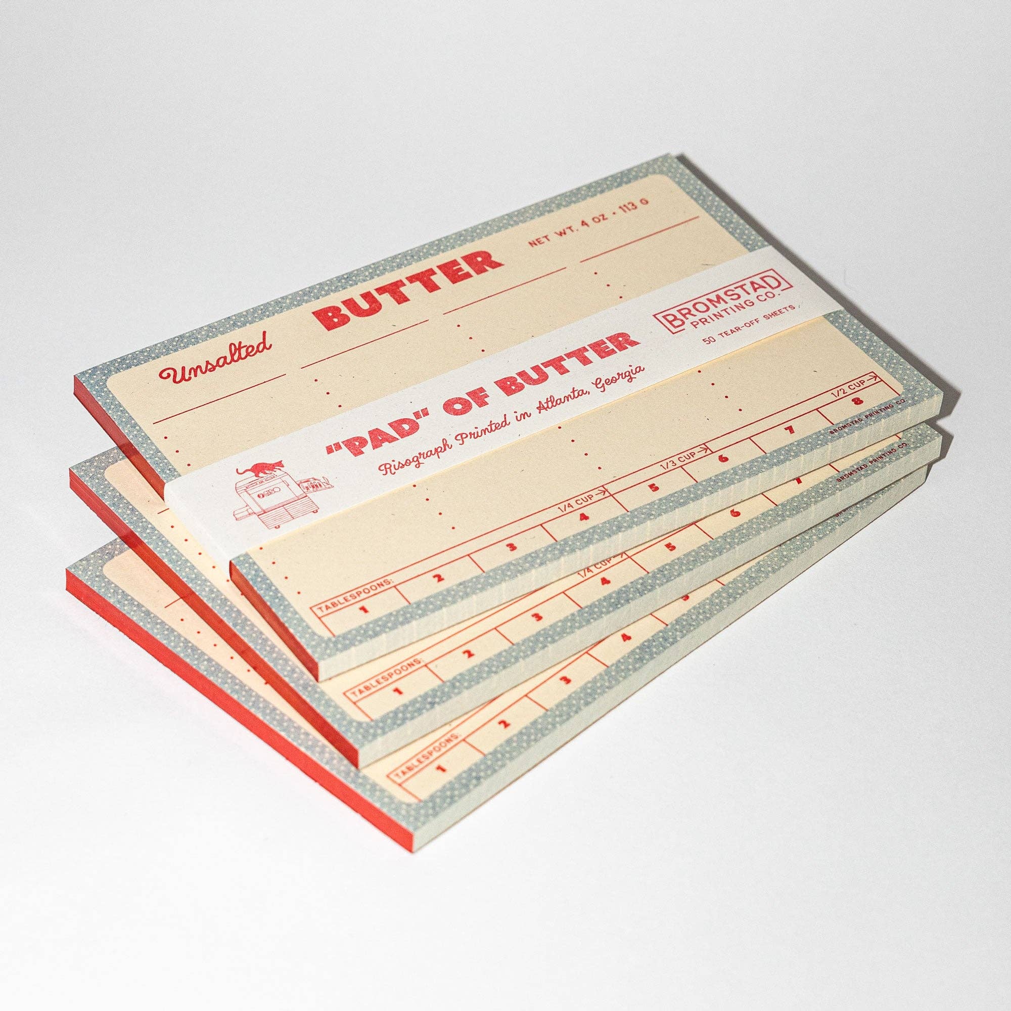 Stack of vintage-style butter planners with red and beige design on a white background