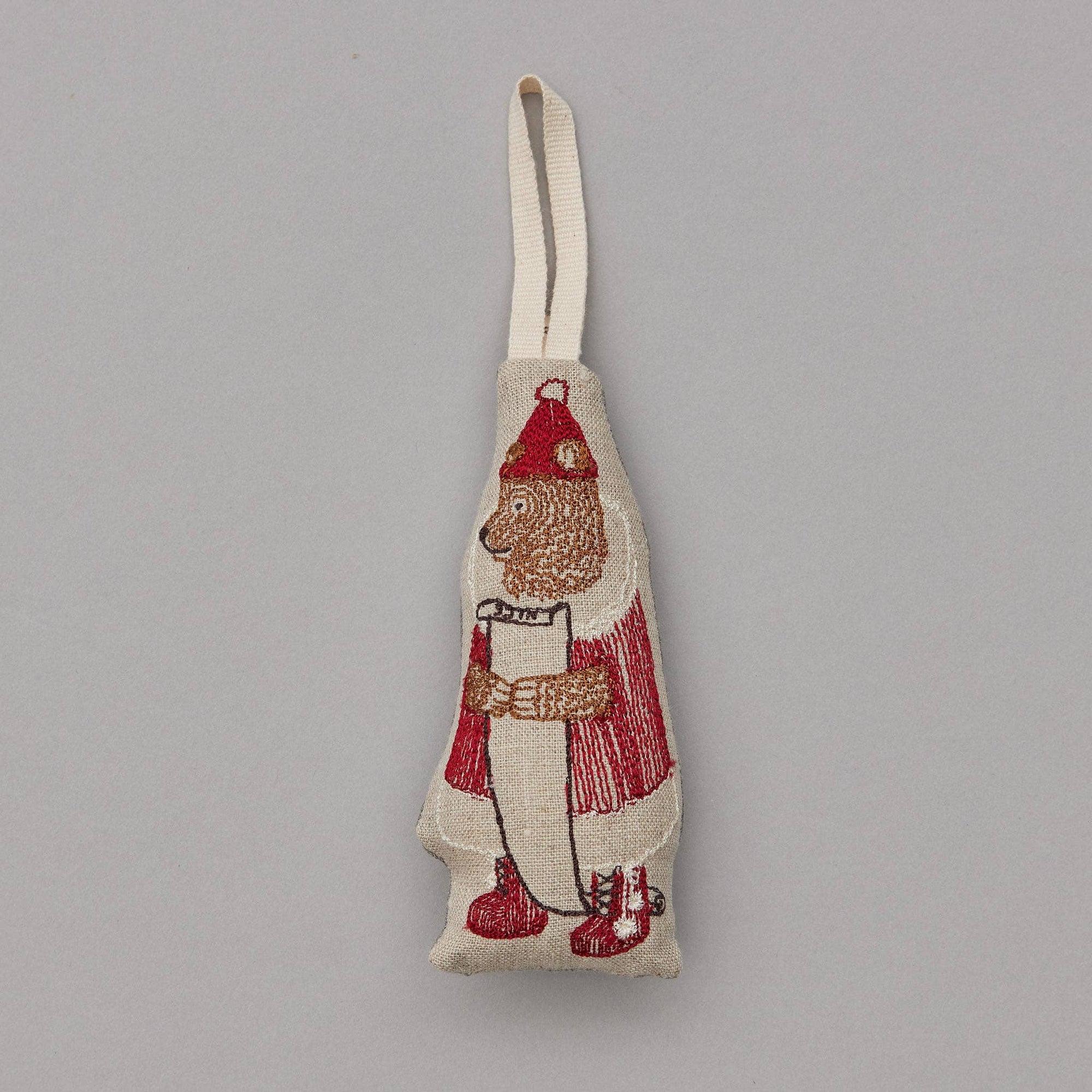 Fabric ornament with a bear design in red and white on a gray background