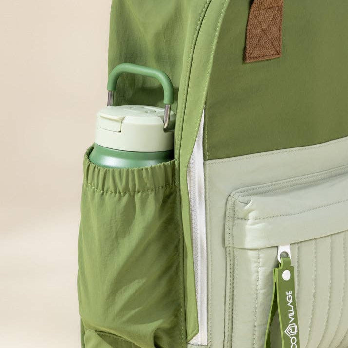 Green backpack with a water bottle in a pocket on a beige background