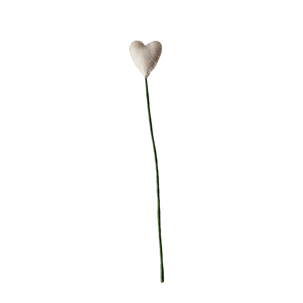 Heart-shaped object on a long stem against a white background