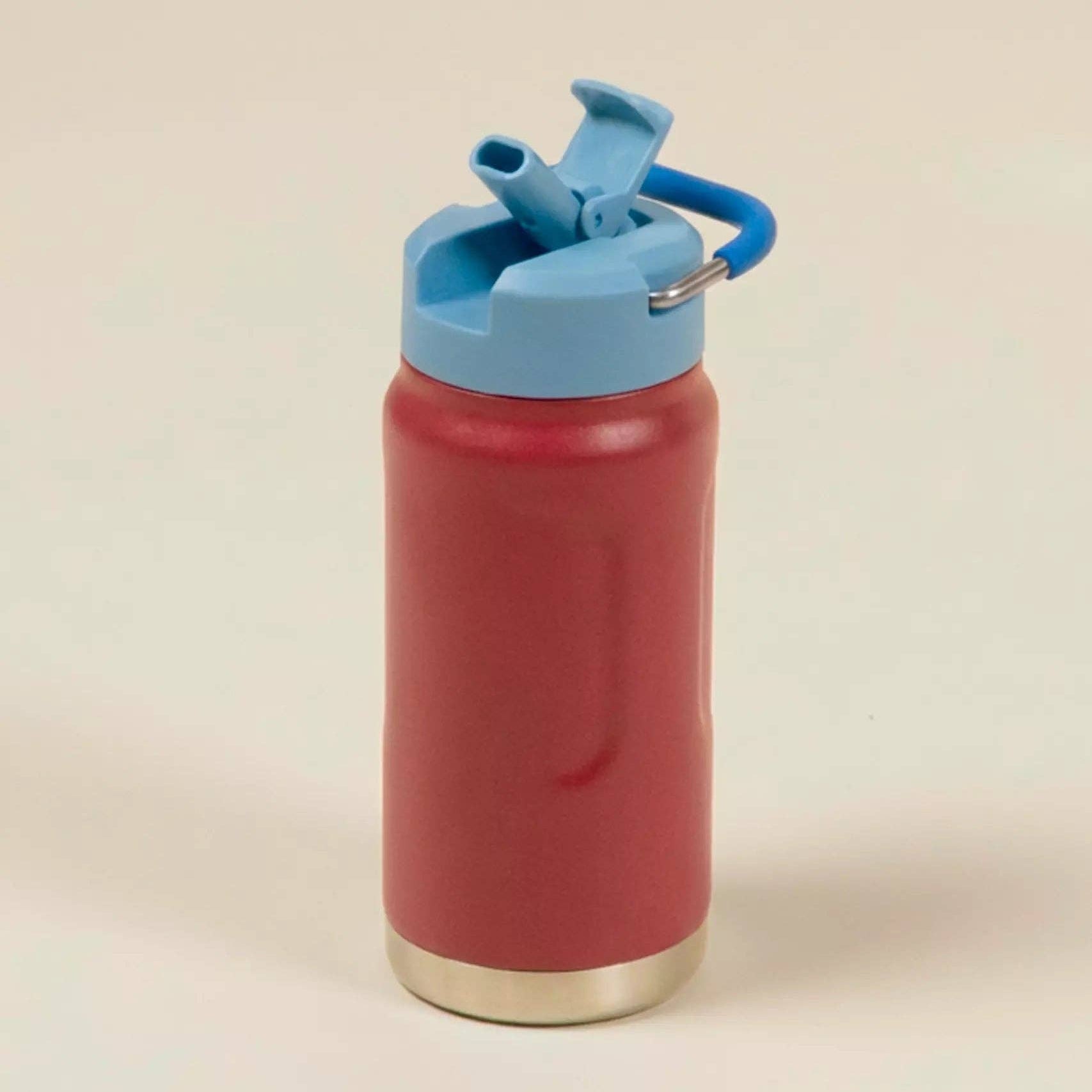 Red water bottle with a blue lid on a beige background