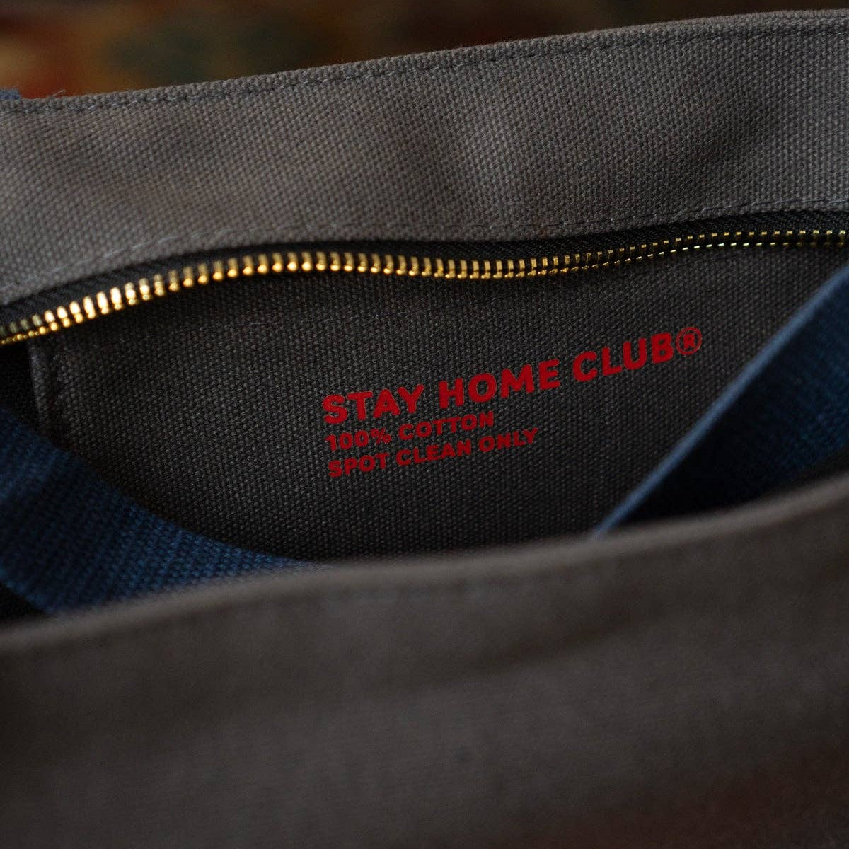 Gray fabric with 'Stay Home Club' logo and text, close-up view.