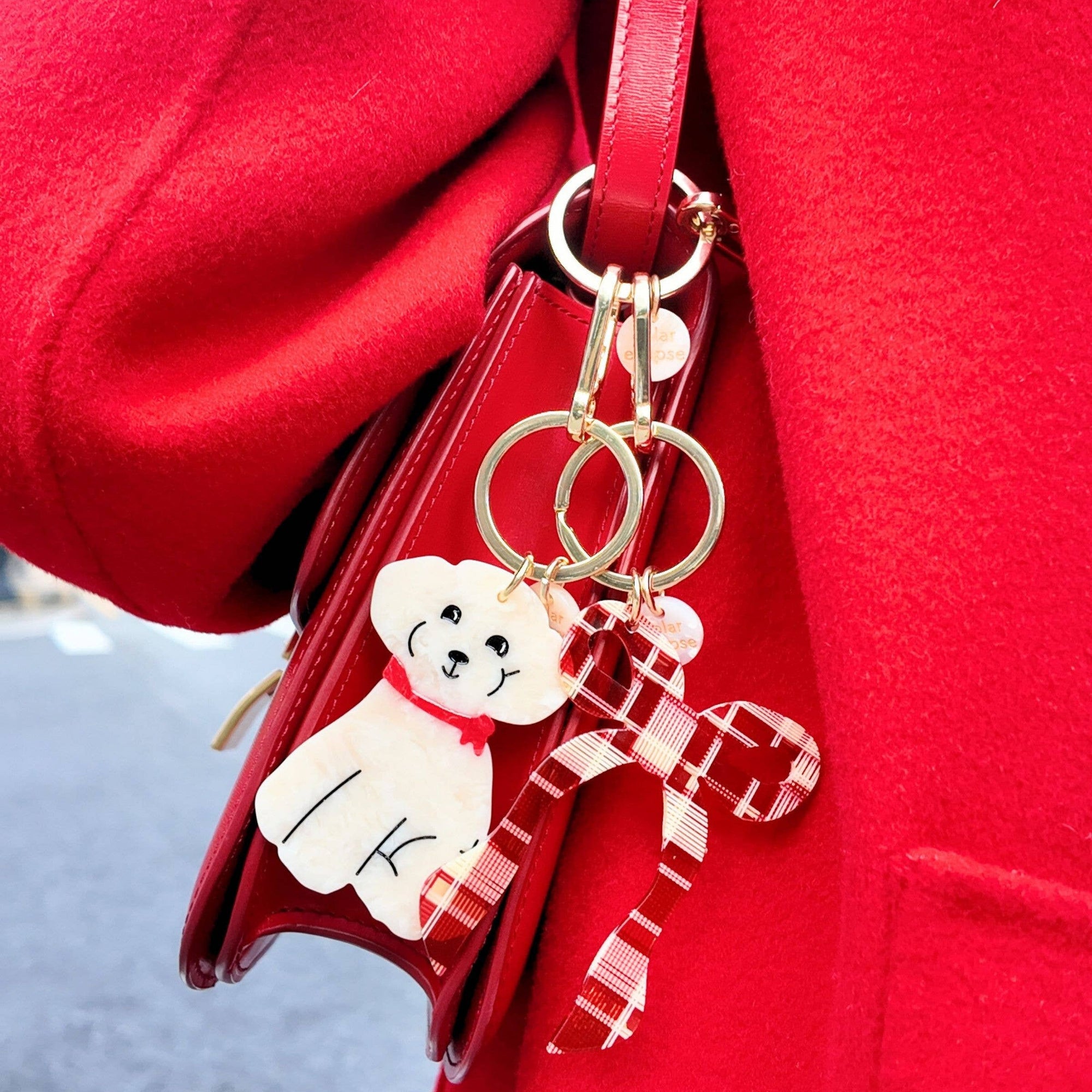 Red bag with a keychain featuring a white dog design on a red background