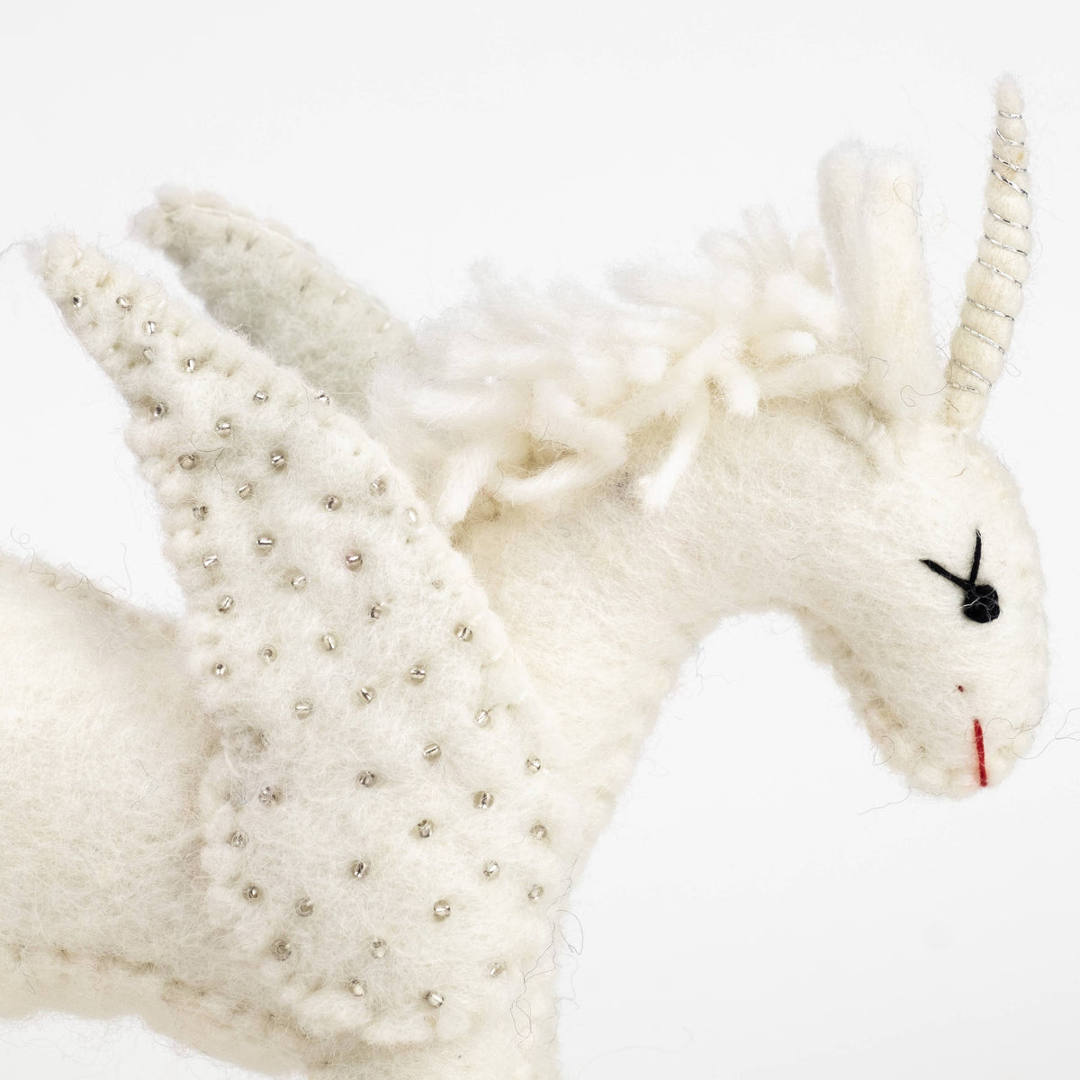 White plush toy with decorative elements on a white background