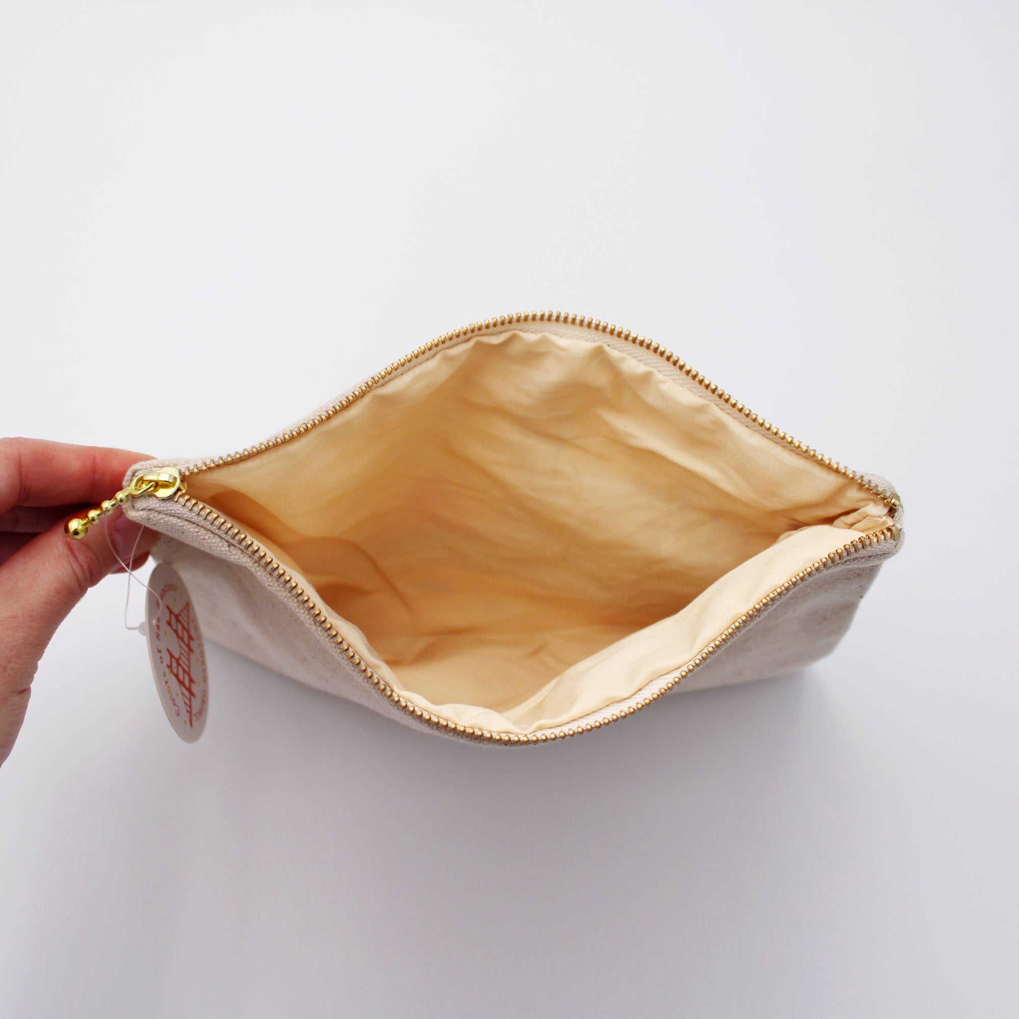 Beige pouch with gold interior on a white background