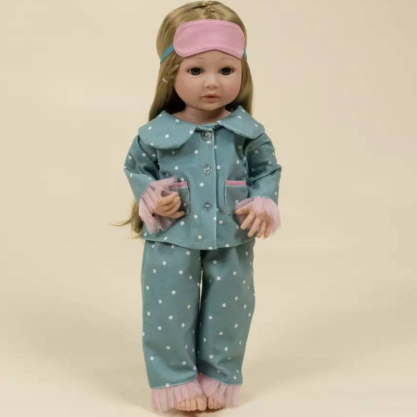 Doll wearing a teal polka dot outfit with pink accents on a beige background