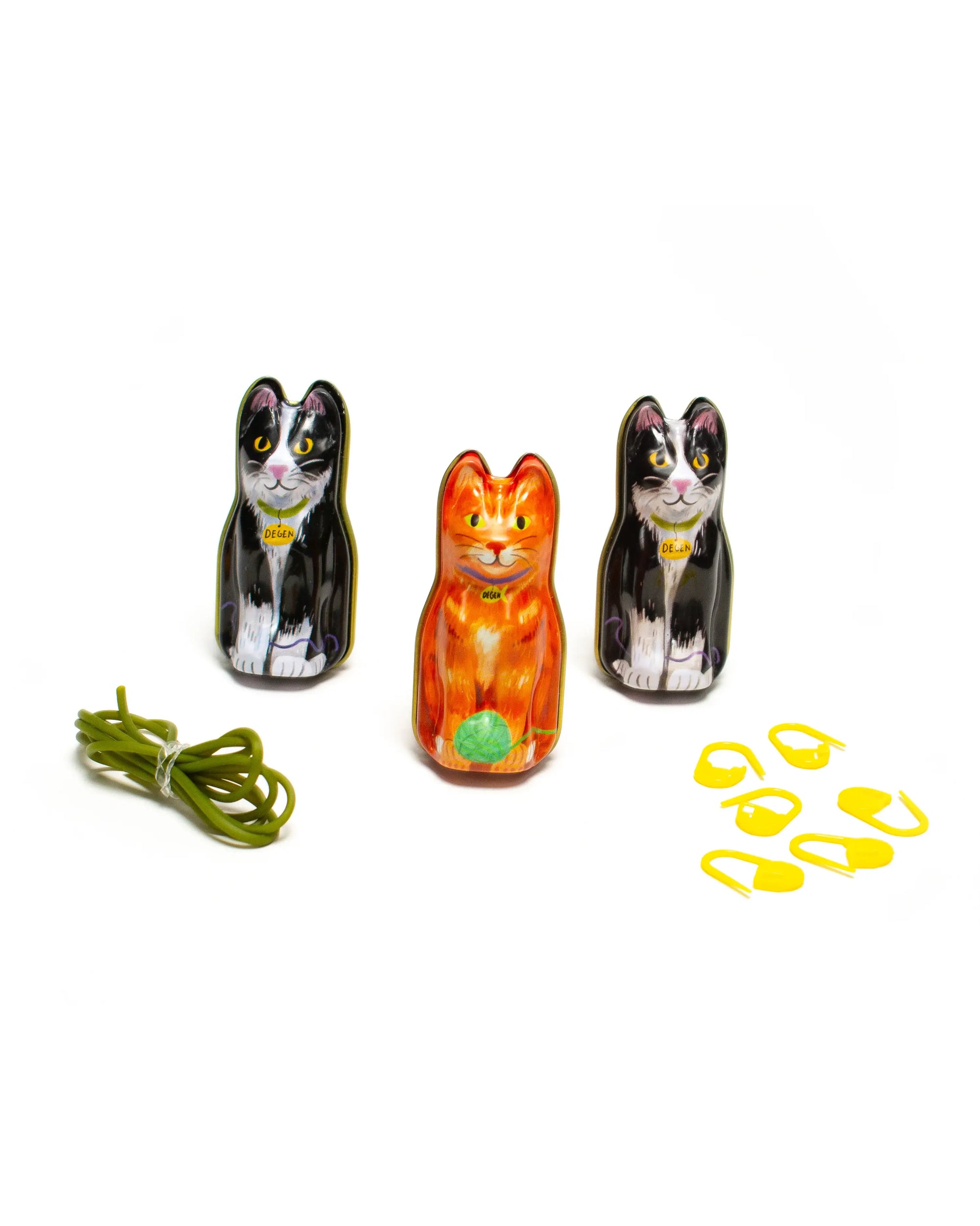 Three cat-shaped containers with a string and bobbers on a white background