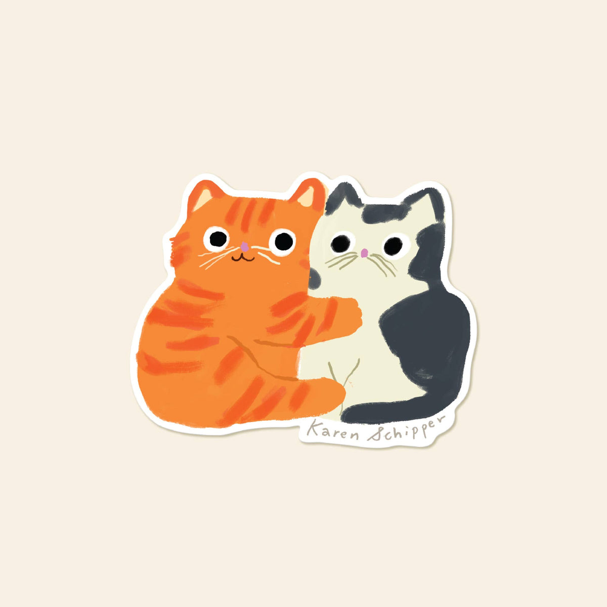 A die-cut sticker featuring a cute cartoon illustration of two cats, one orange tabby and one black-and-white, hugging. The sticker is shown on a solid light beige background.