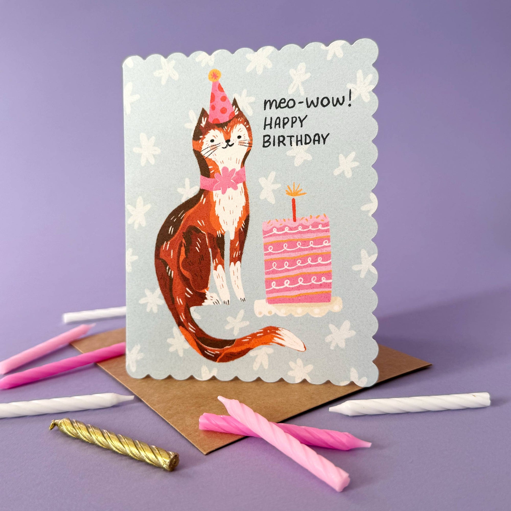 Birthday card with a cat illustration and birthday cake, surrounded by candles on a purple background.