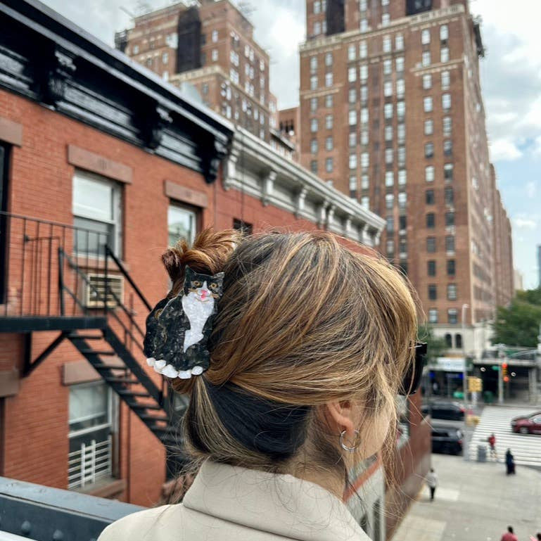 Person with a hair accessory in an urban setting with tall buildings.