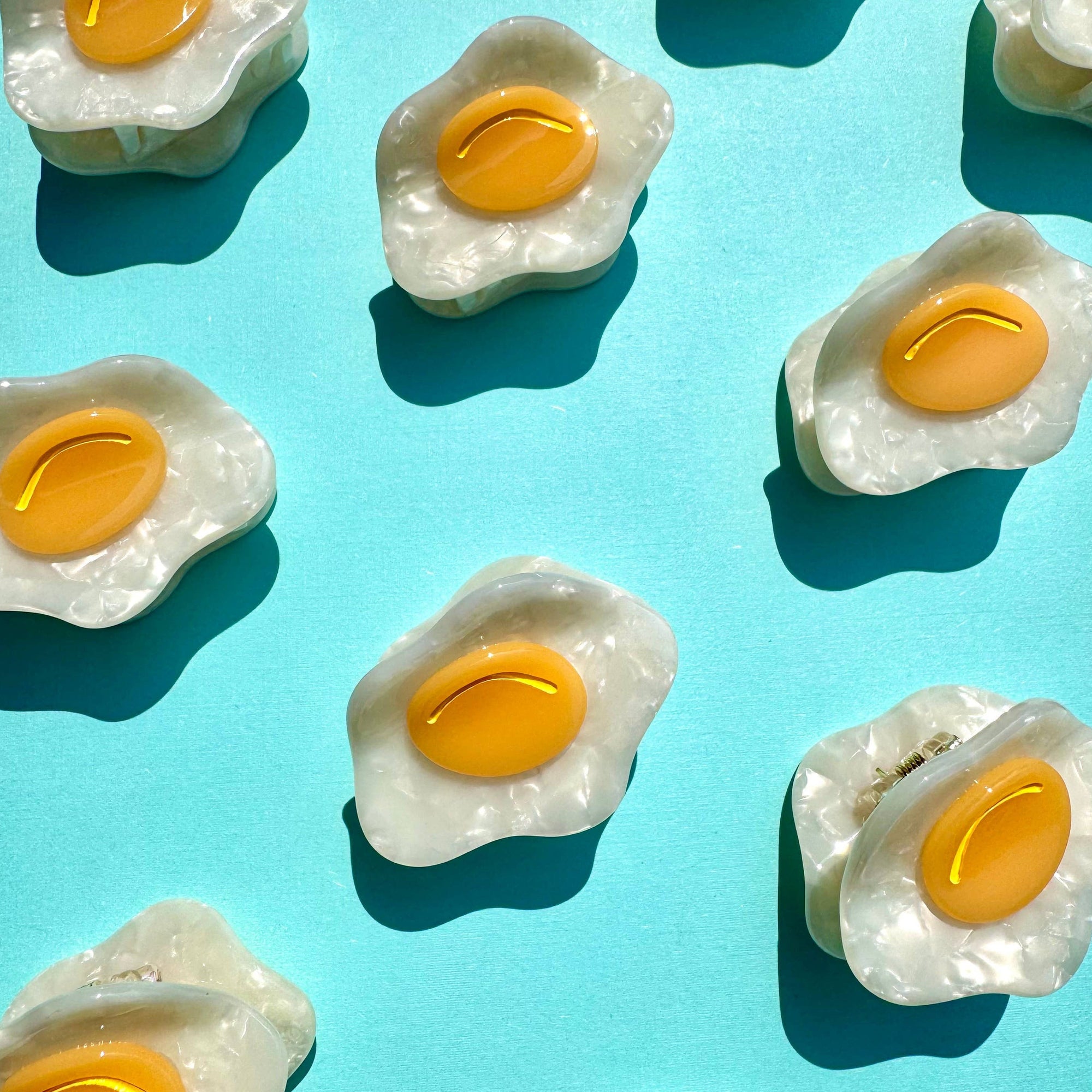 Pattern of fried egg-shaped candies on a blue background