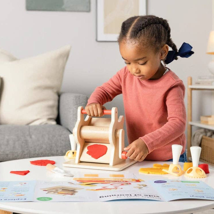 Child playing with a wooden toy at a table in a living room.