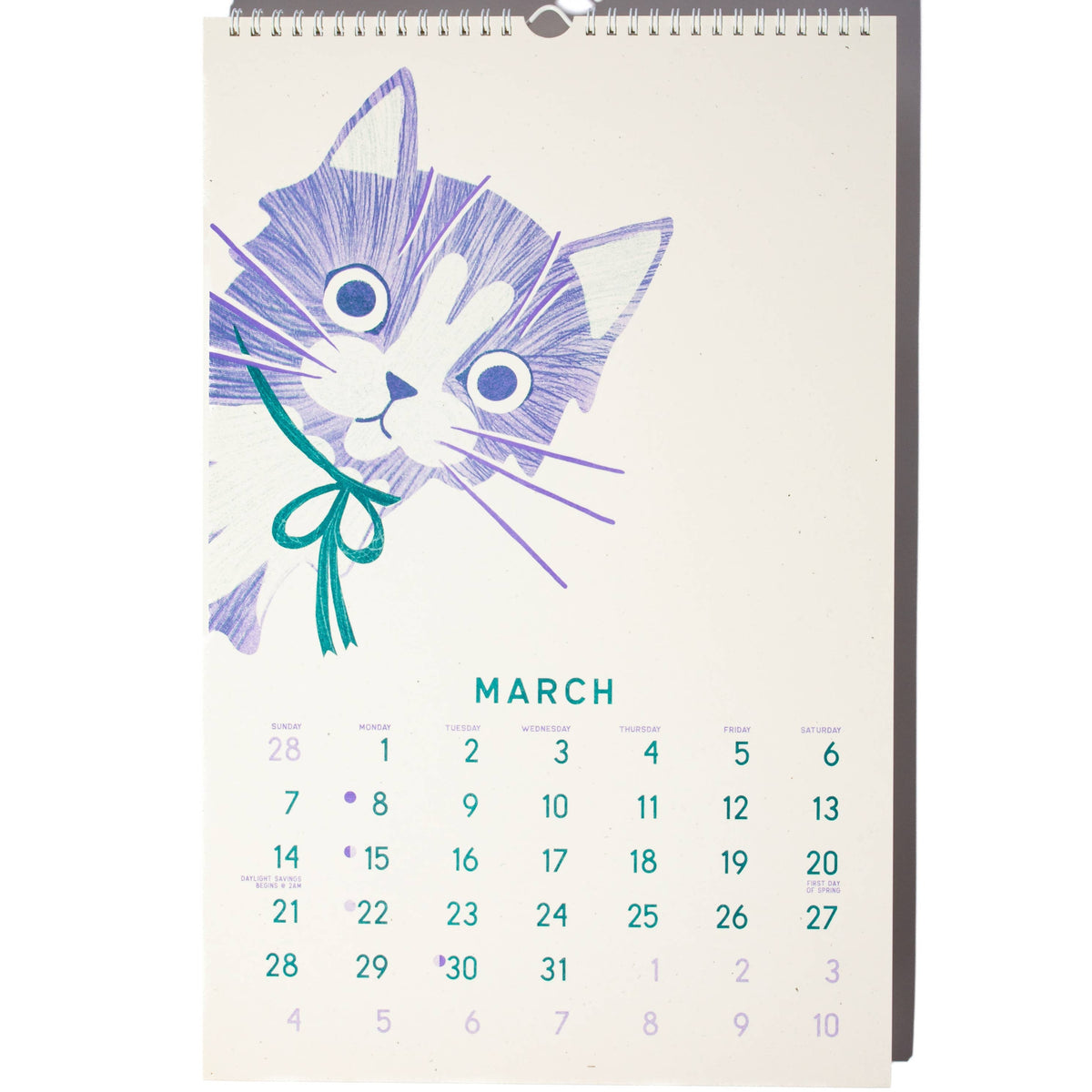 A spiral-bound desk calendar page featuring a purple line-art illustration of a cat holding a teal bow, with the month March and numbered days below on a white background.