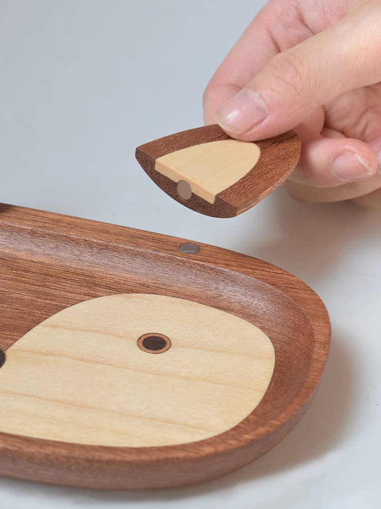 Wooden product with a hand interacting with it on a light background