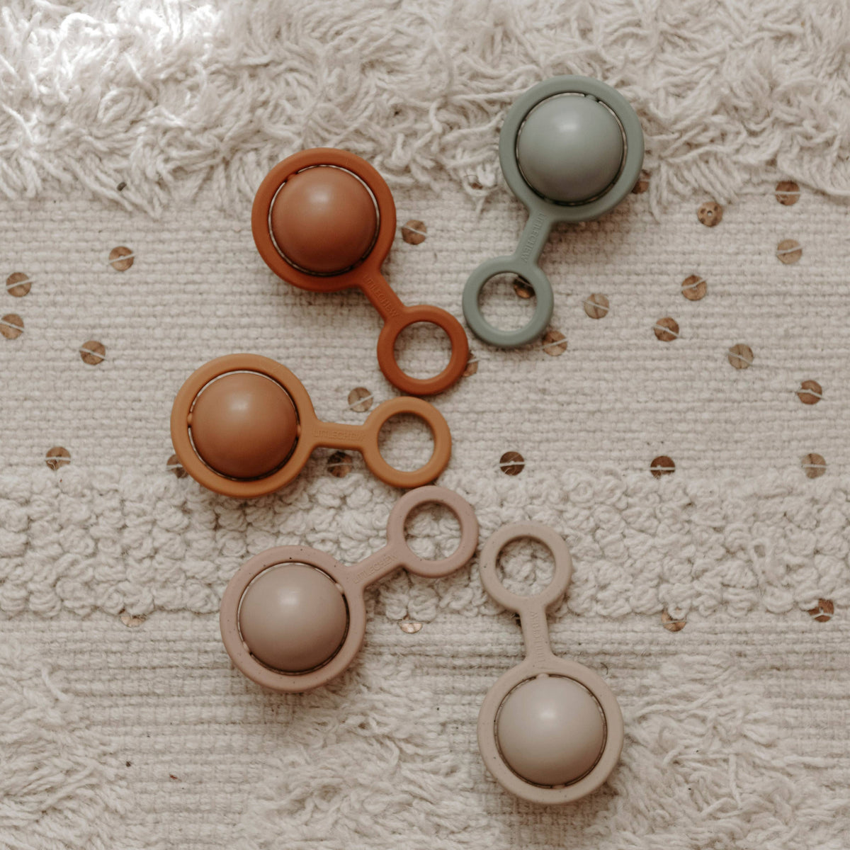 Set of four round objects on a textured beige surface