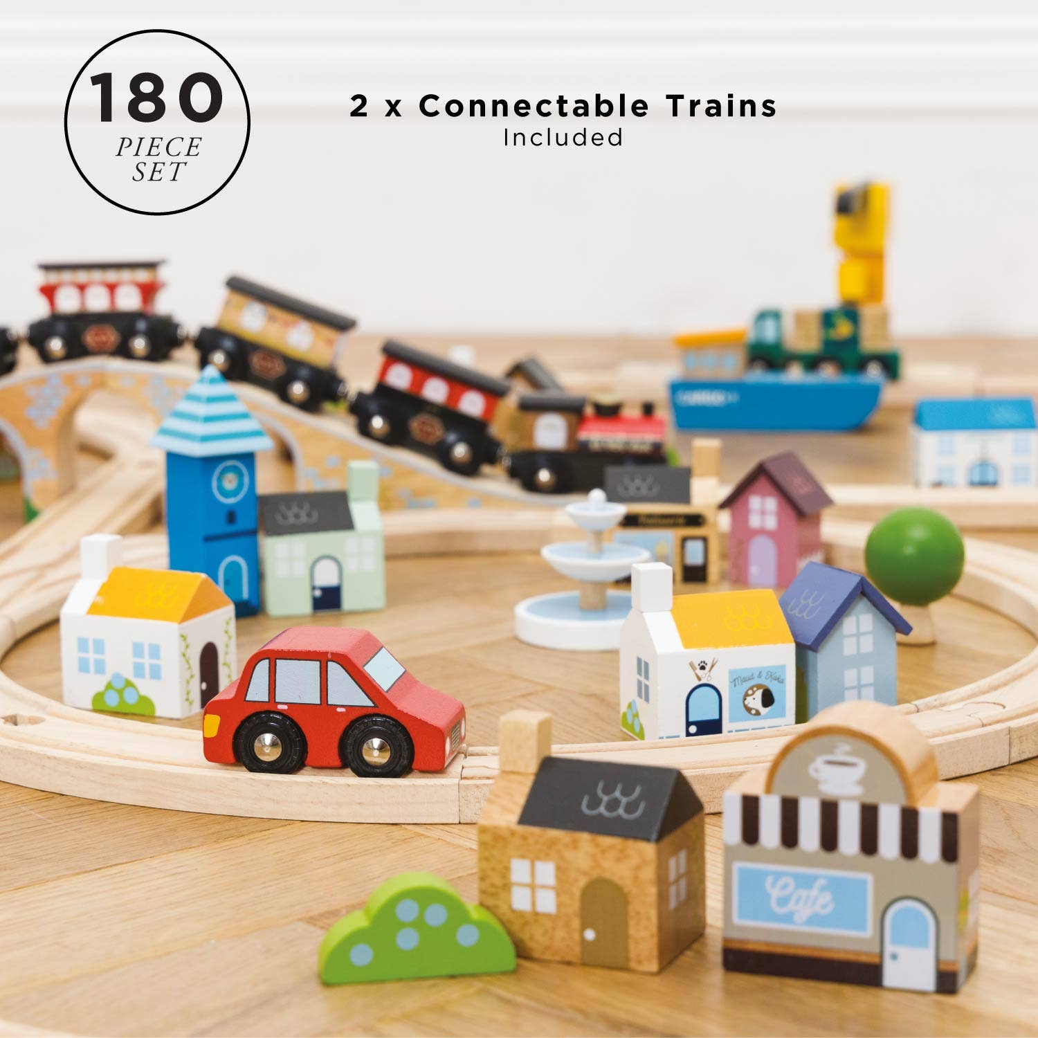 Wooden toy train set with connectable trains, houses, and a car on a wooden track.