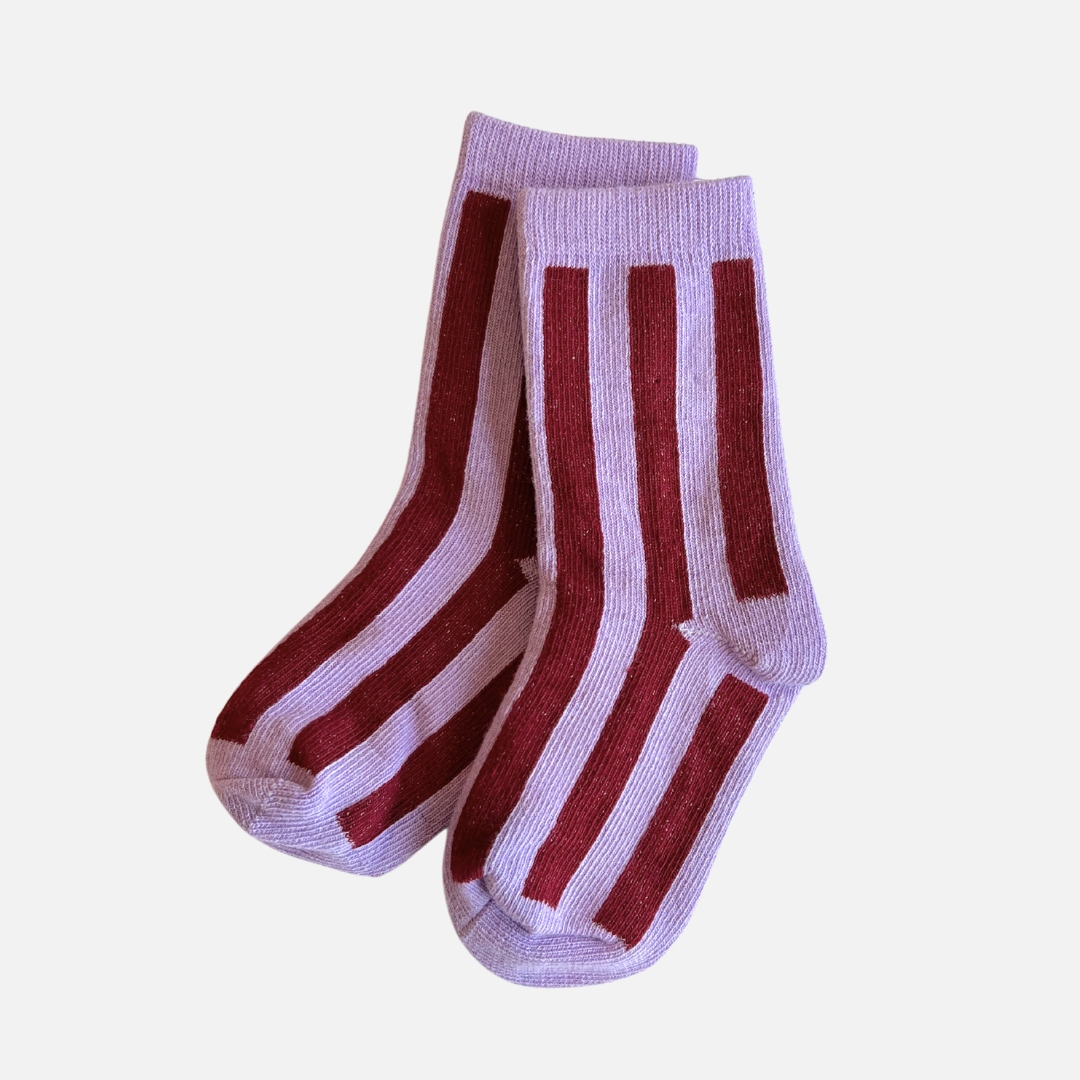 Pair of socks with red and white stripes on a light purple background