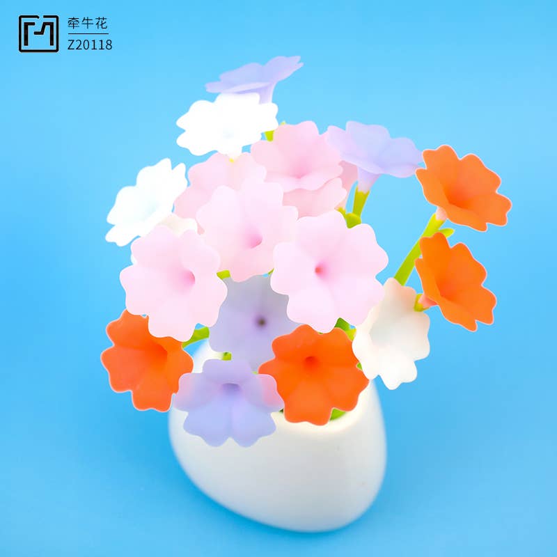 Colorful artificial flowers in a white vase on a blue background