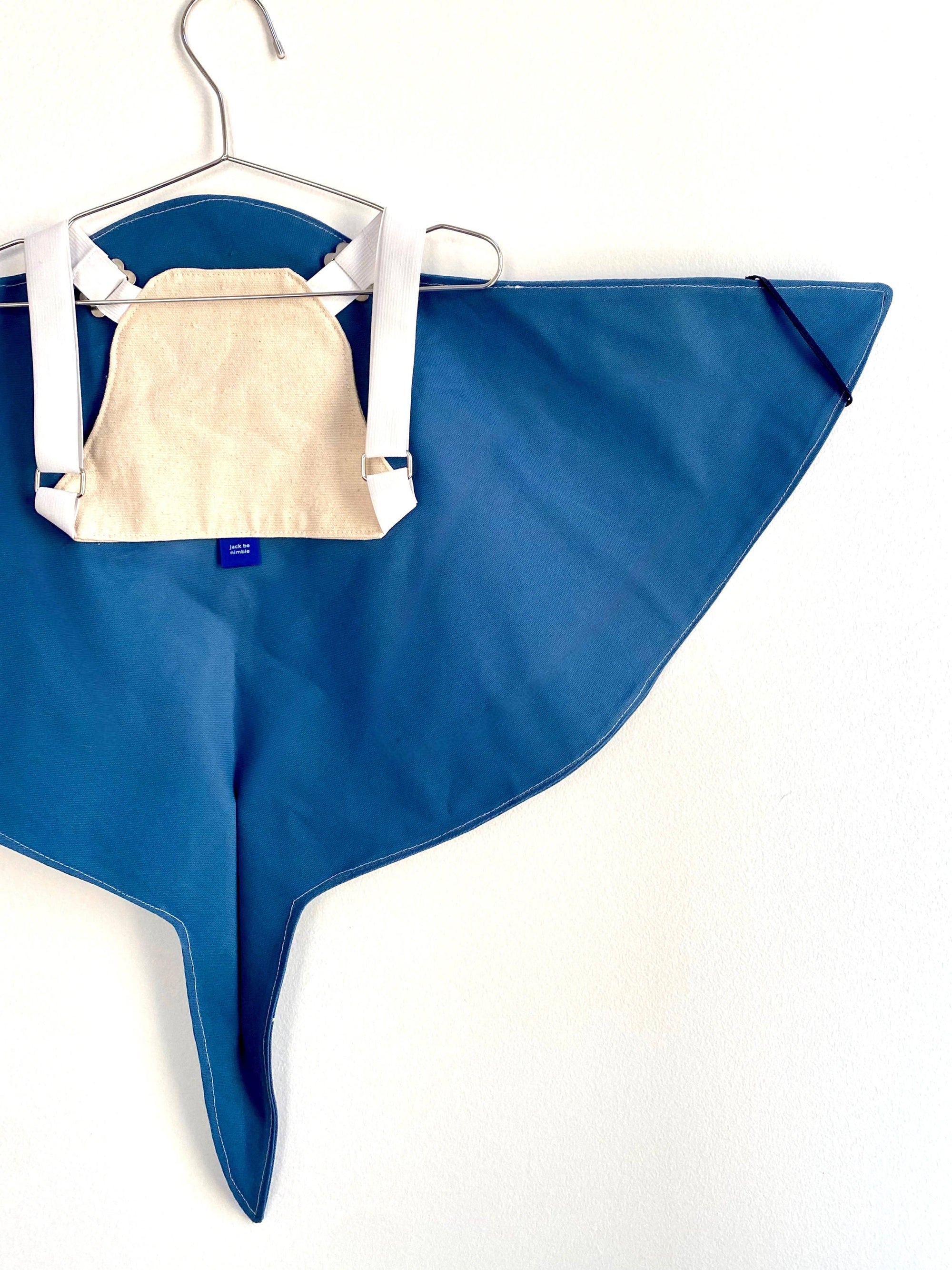 Blue fabric with a white garment on a hanger against a white background