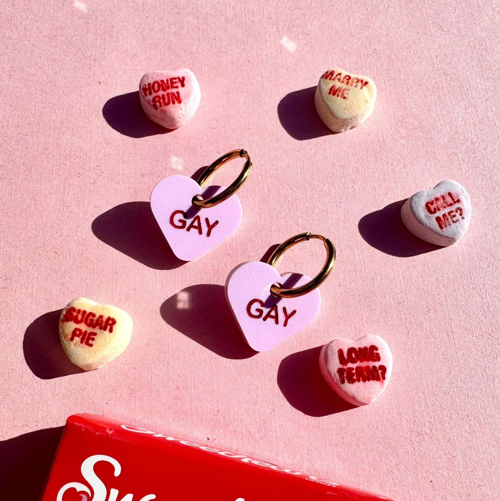 Sweethearts candy on a pink background with 'Gay' and other text