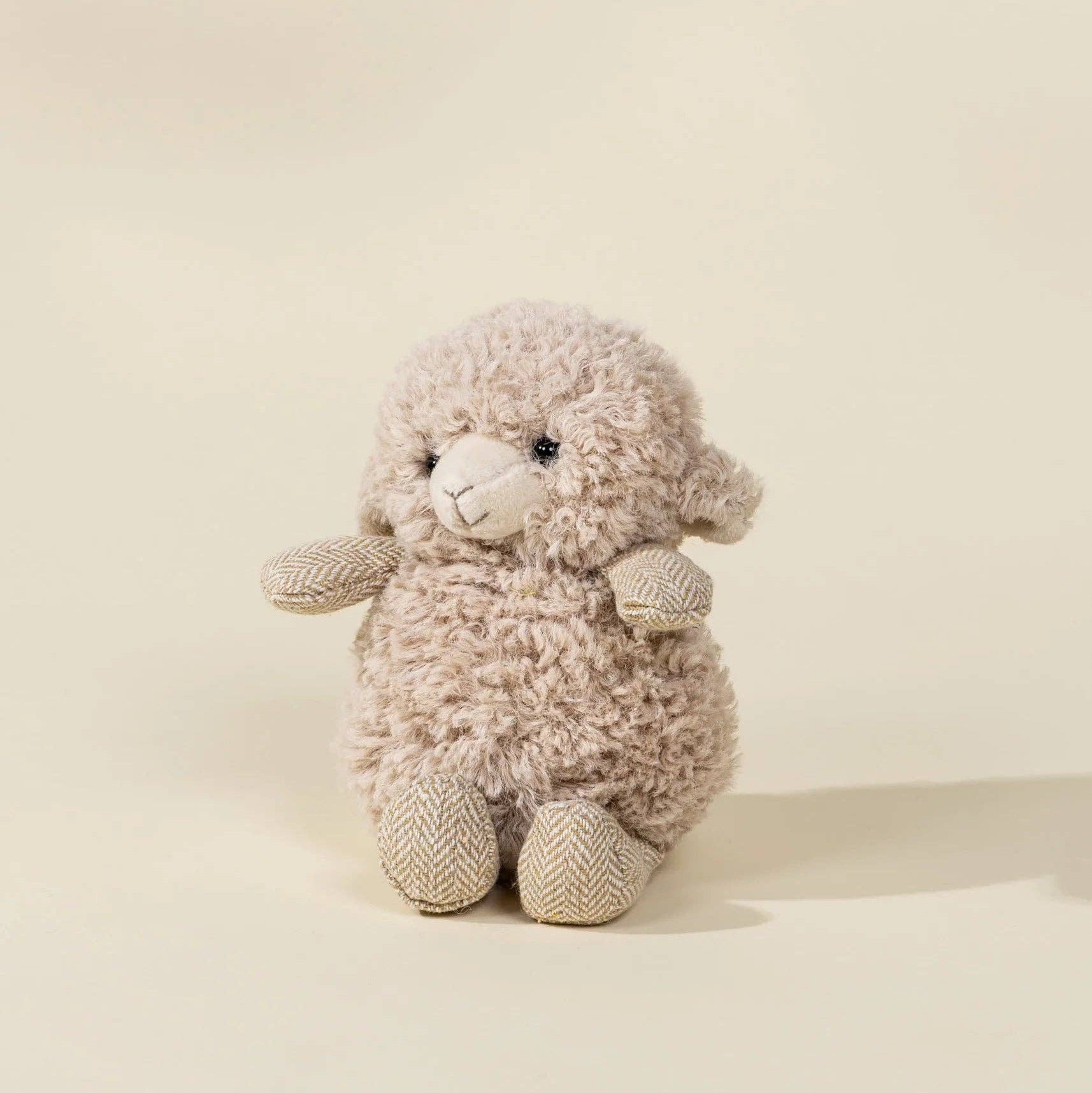 Plush lamb toy on a beige background