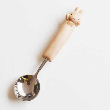 Spoon with a wooden handle shaped like a dog on a white background