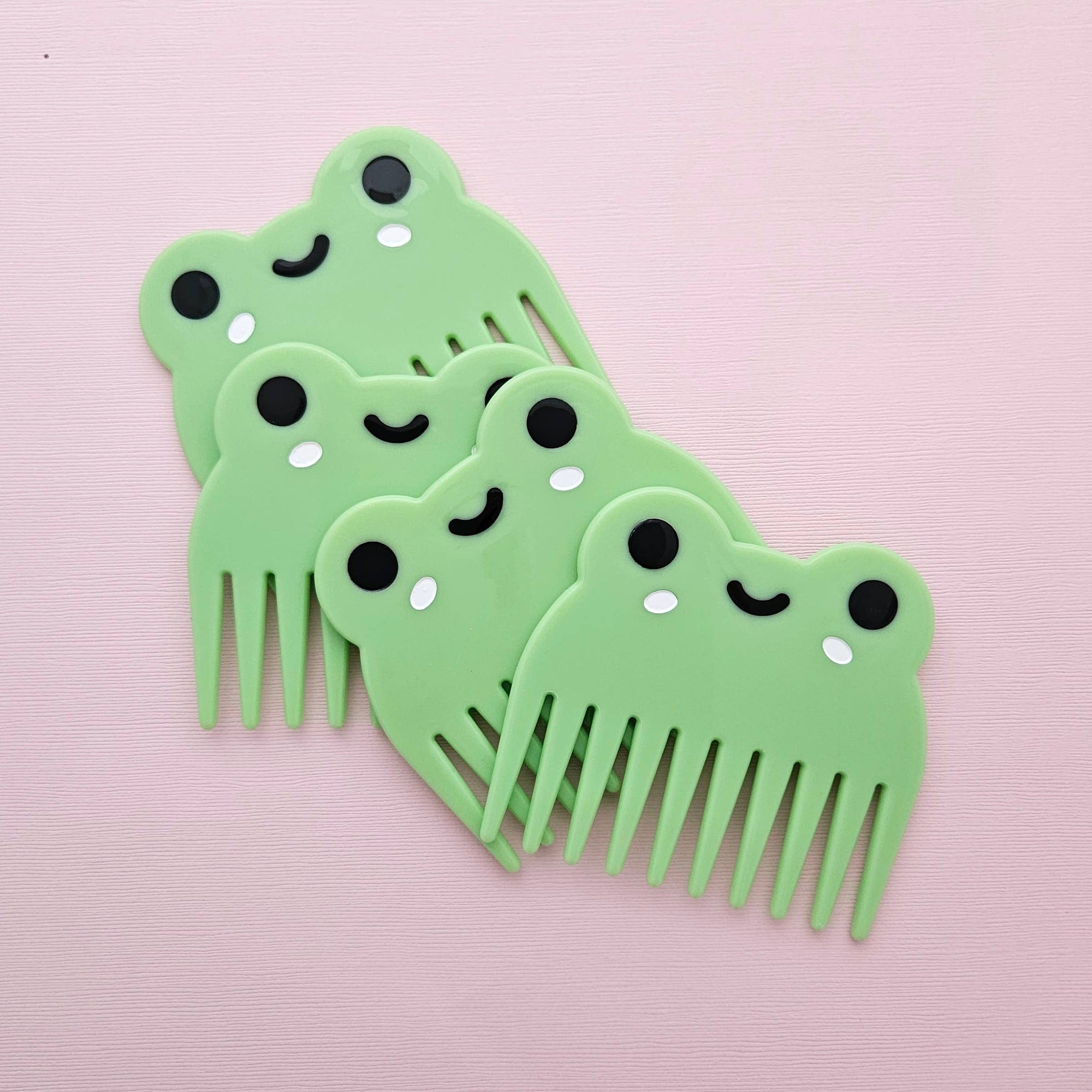 Set of green combs with smiling faces on a pink background