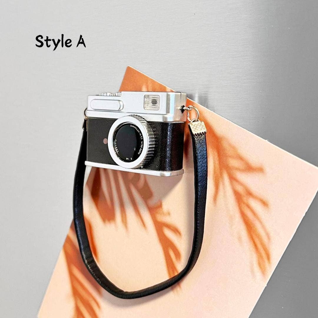 Vintage camera with a black strap on a light gray background
