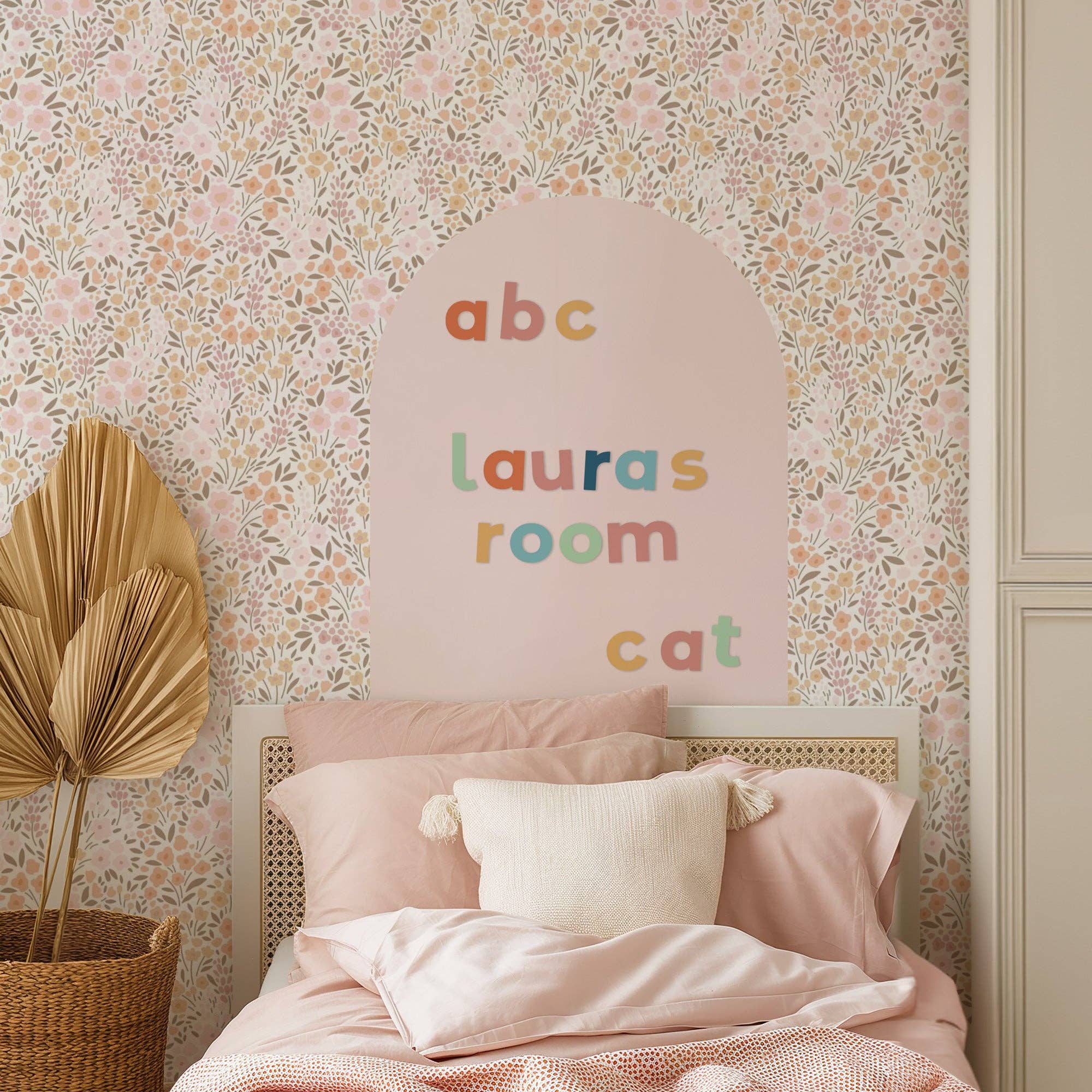 Children's bedroom with floral wallpaper, 'abc lauras room cat' sign, and pink bedding.