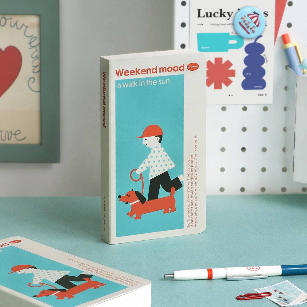 Notebook titled 'Weekend mood' with a dog illustration on a teal surface.