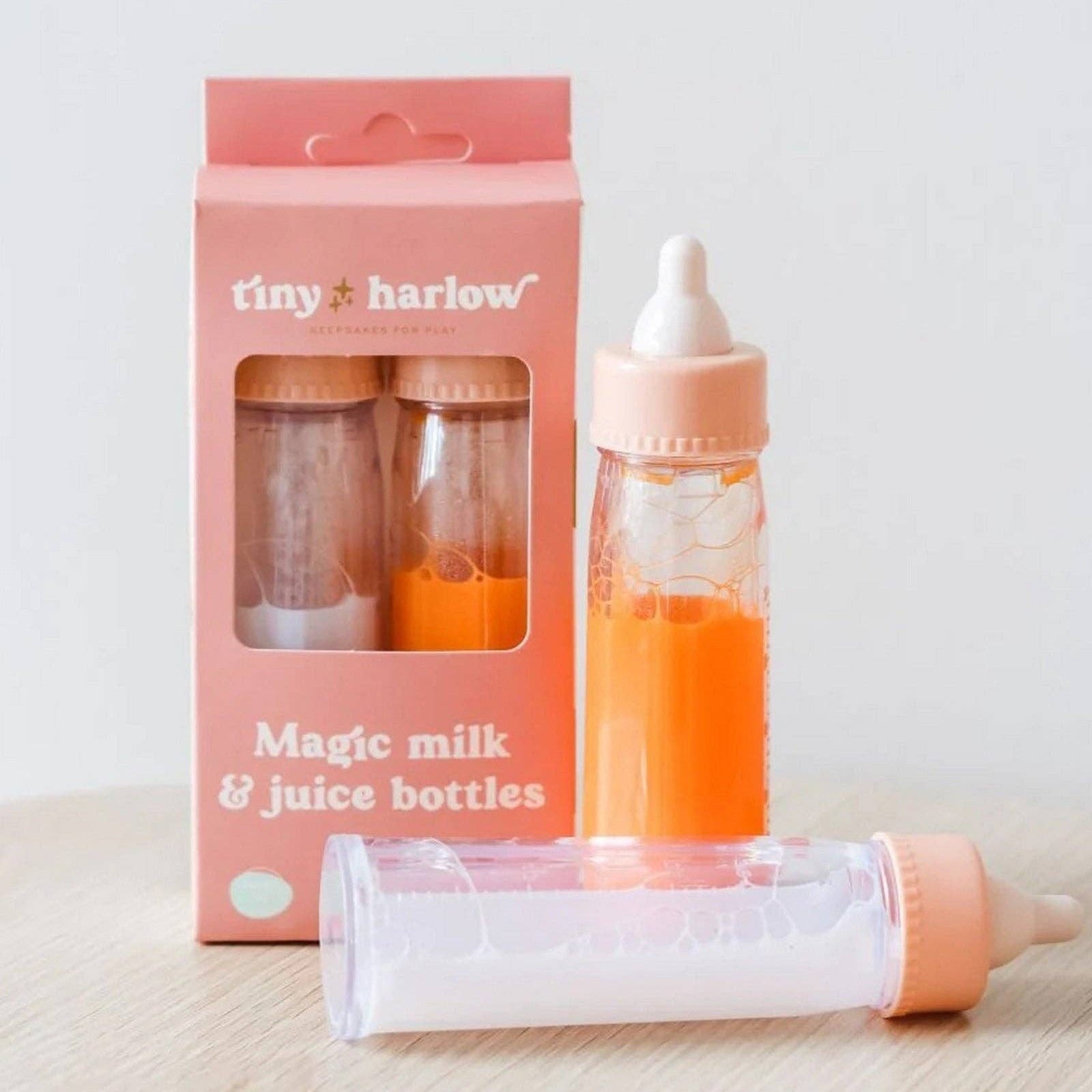 Pink magic milk and juice bottles with packaging on a light background