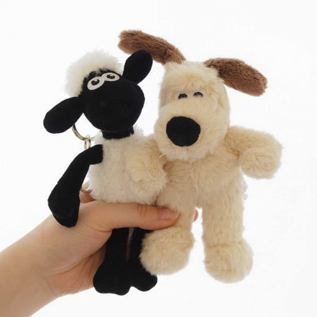 Two plush toys, one black and white sheep and one beige dog, held by a hand against a light background.