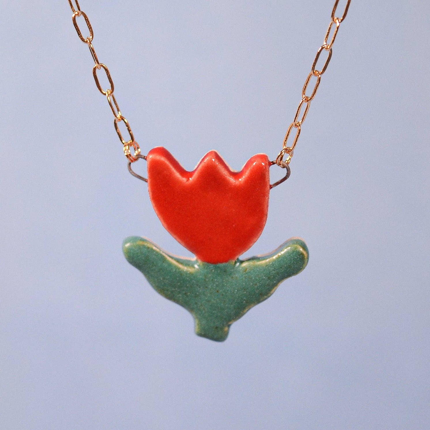 Necklace with a red tulip pendant on a blue background