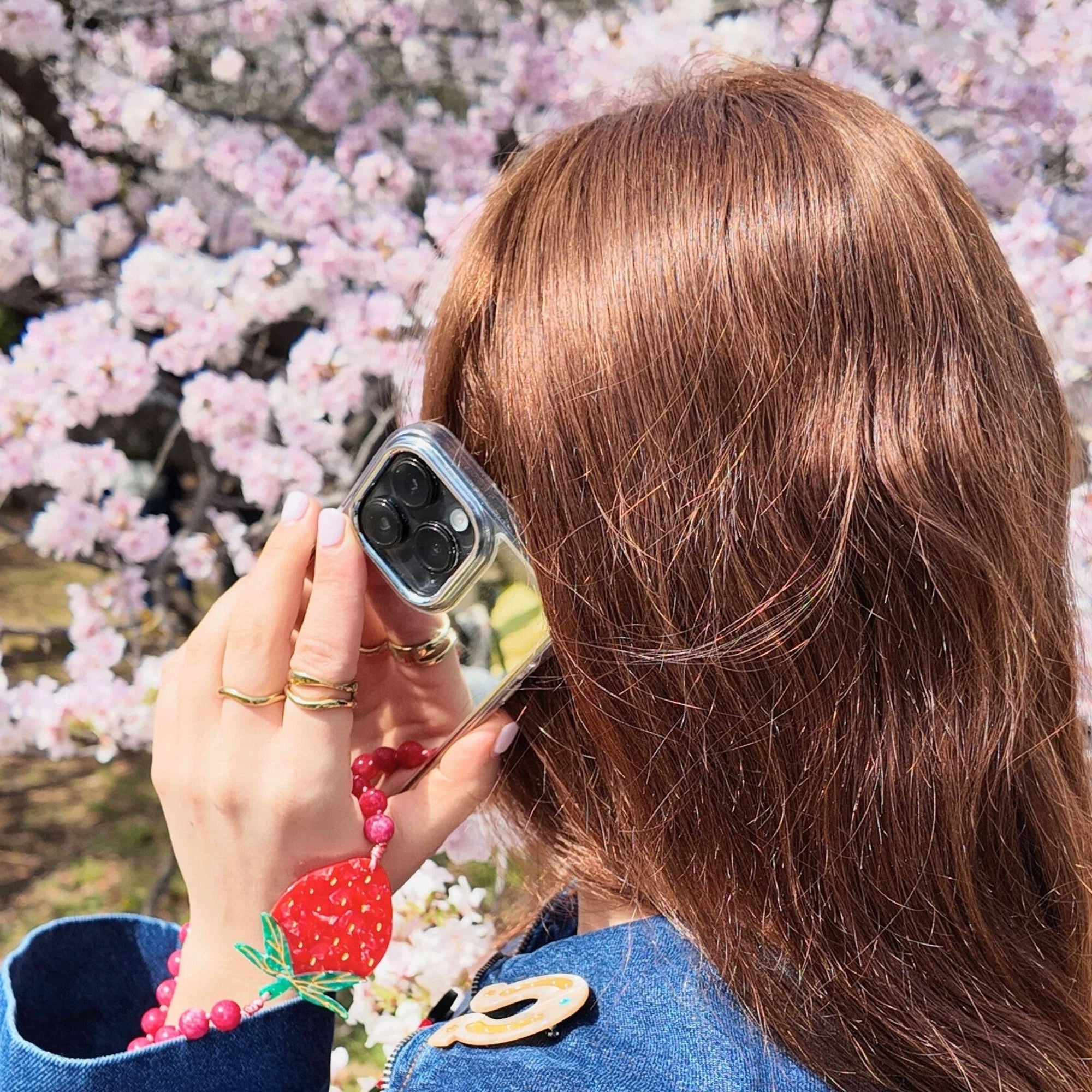 Person wearing a smartwatch with cherry blossoms in the background