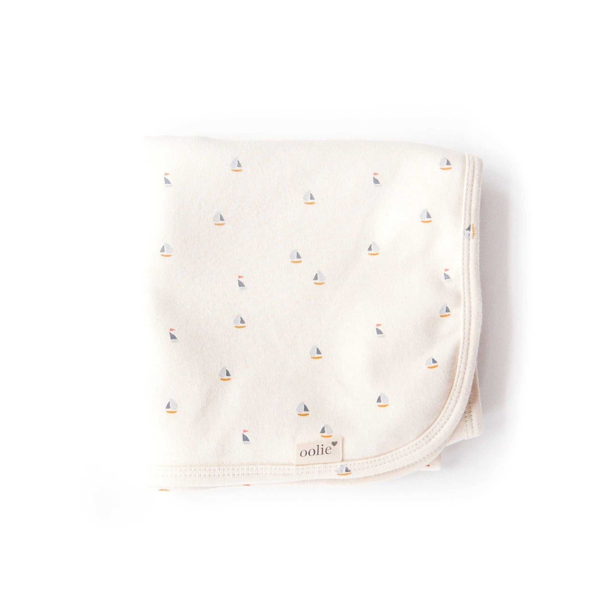 Baby blanket with sailboat pattern on a white background