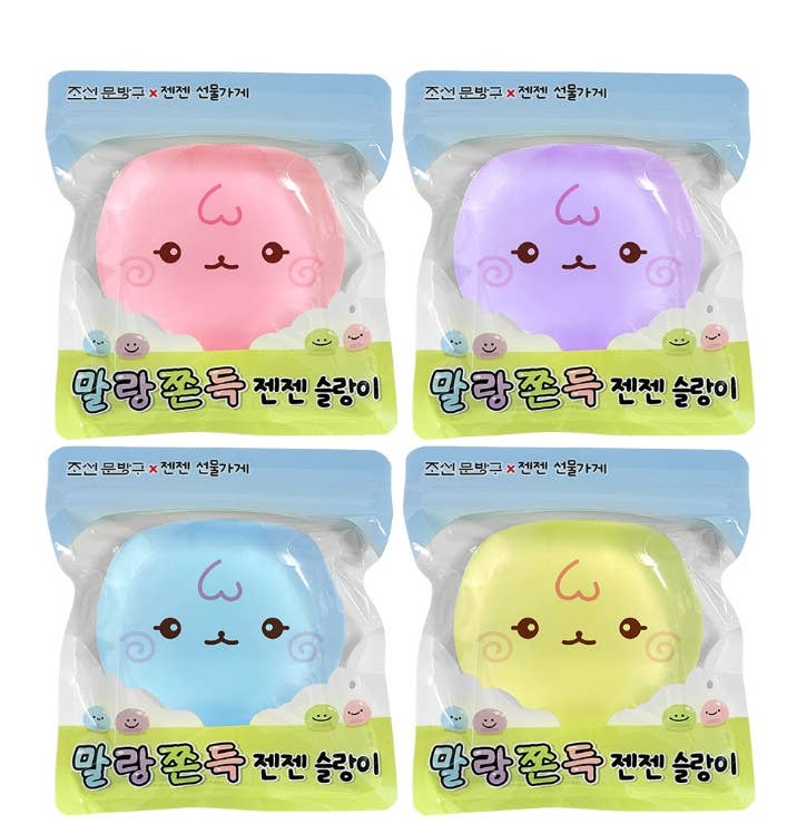Four packaged squishy toys arranged in a 2x2 grid on a white background. Each toy is in its own clear plastic package with a blue header and green bottom label, featuring pastel pink, purple, blue, and yellow rounded shapes with cute cartoon faces.