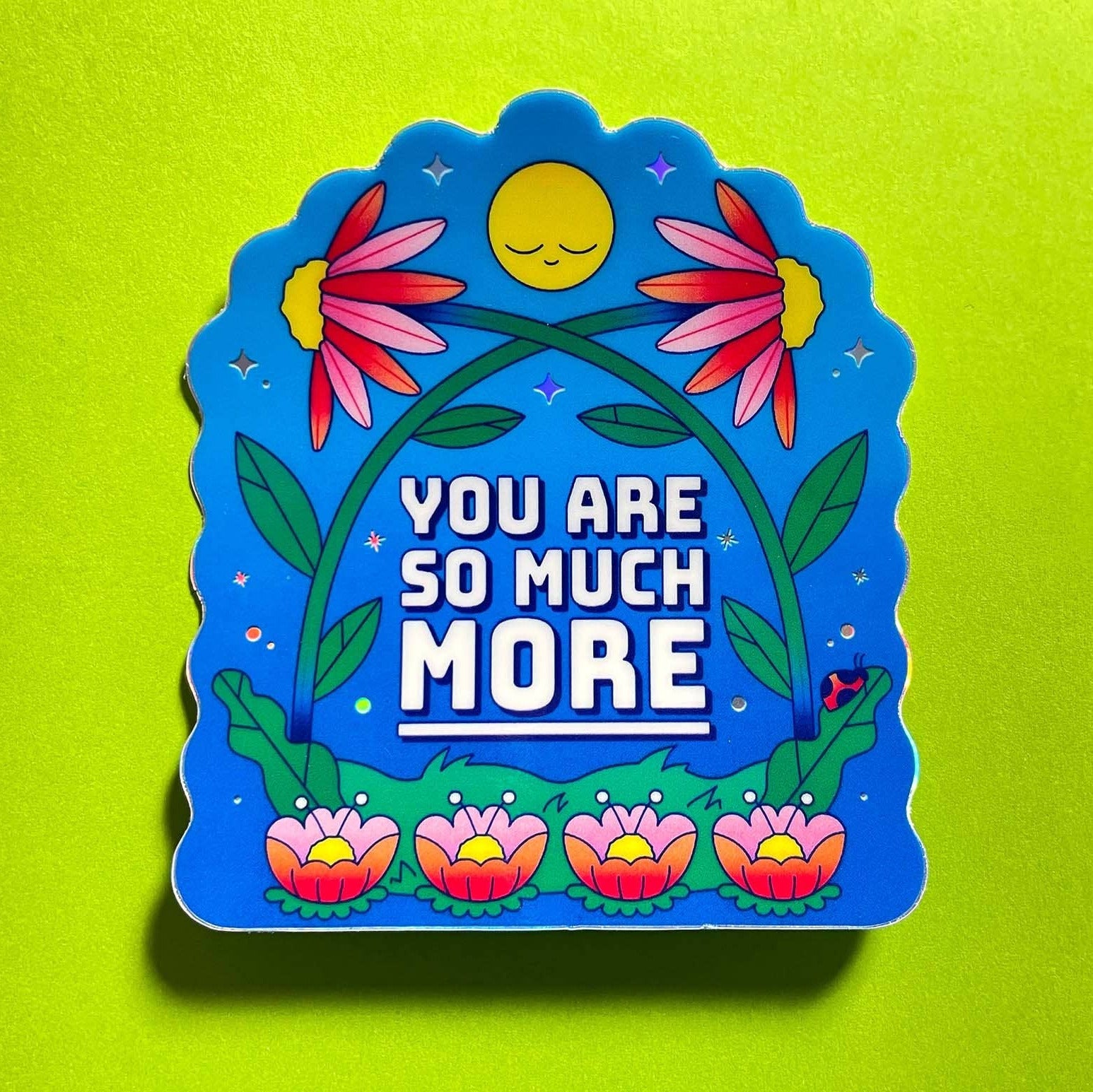 Decorative sticker with floral design and motivational text on a green background
