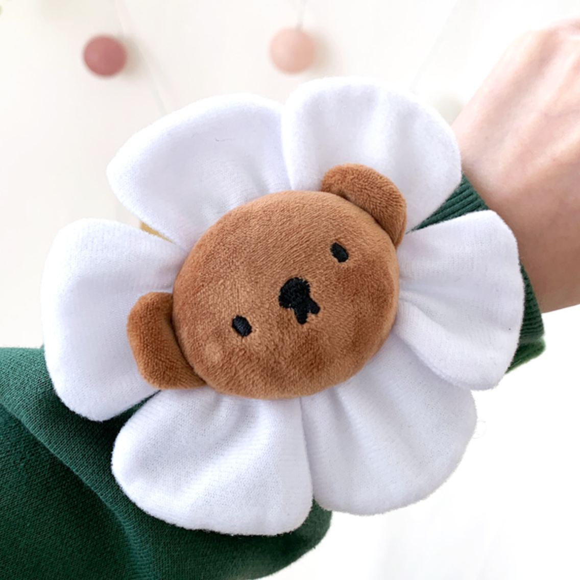Flower-shaped plushie with a bear face on a white background