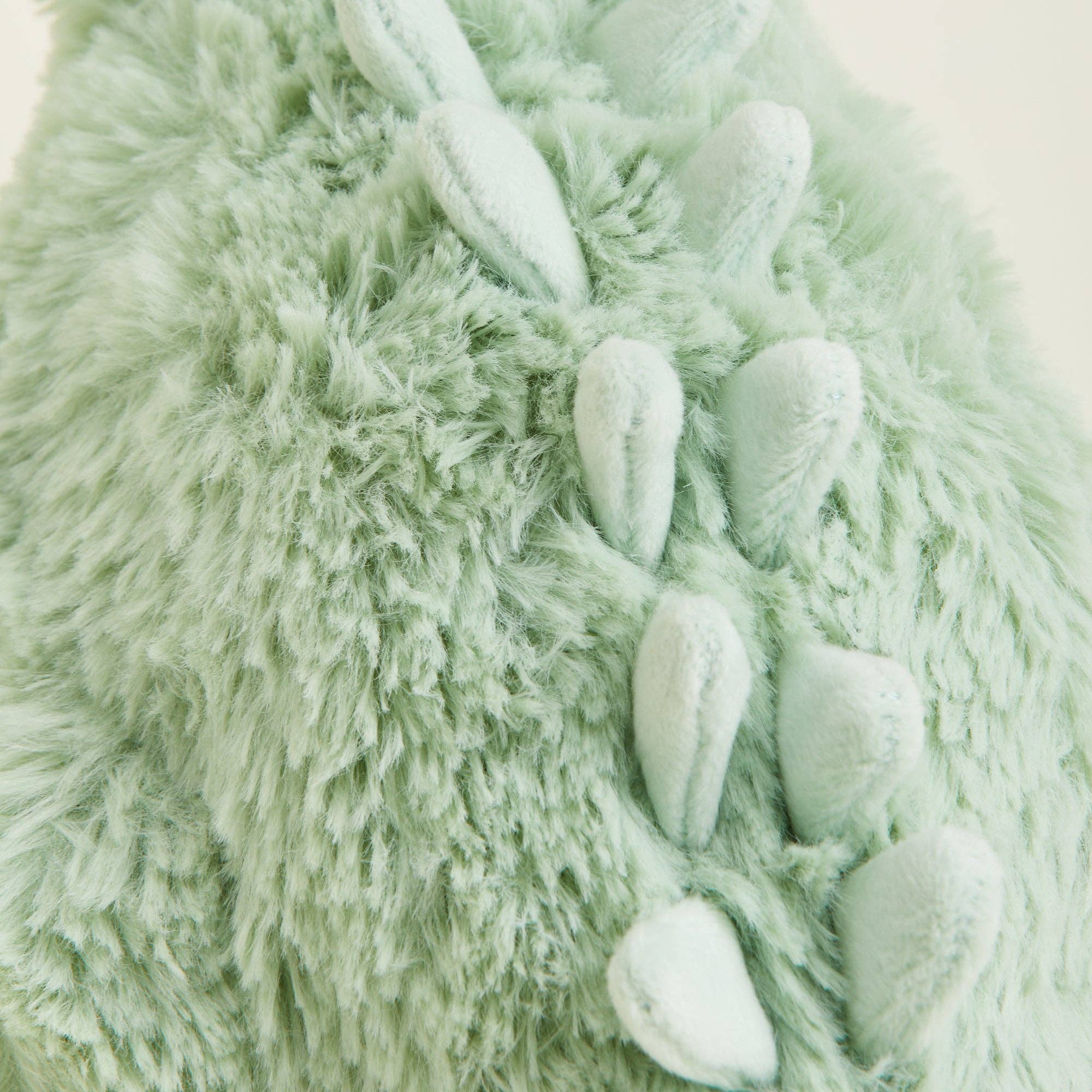 Close-up of a green textured fabric with embroidered elements