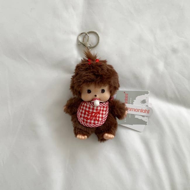 Plush monkey keychain with a tag on a white background