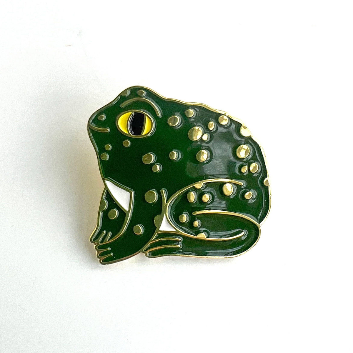 Green frog-shaped pin with gold accents on a white background