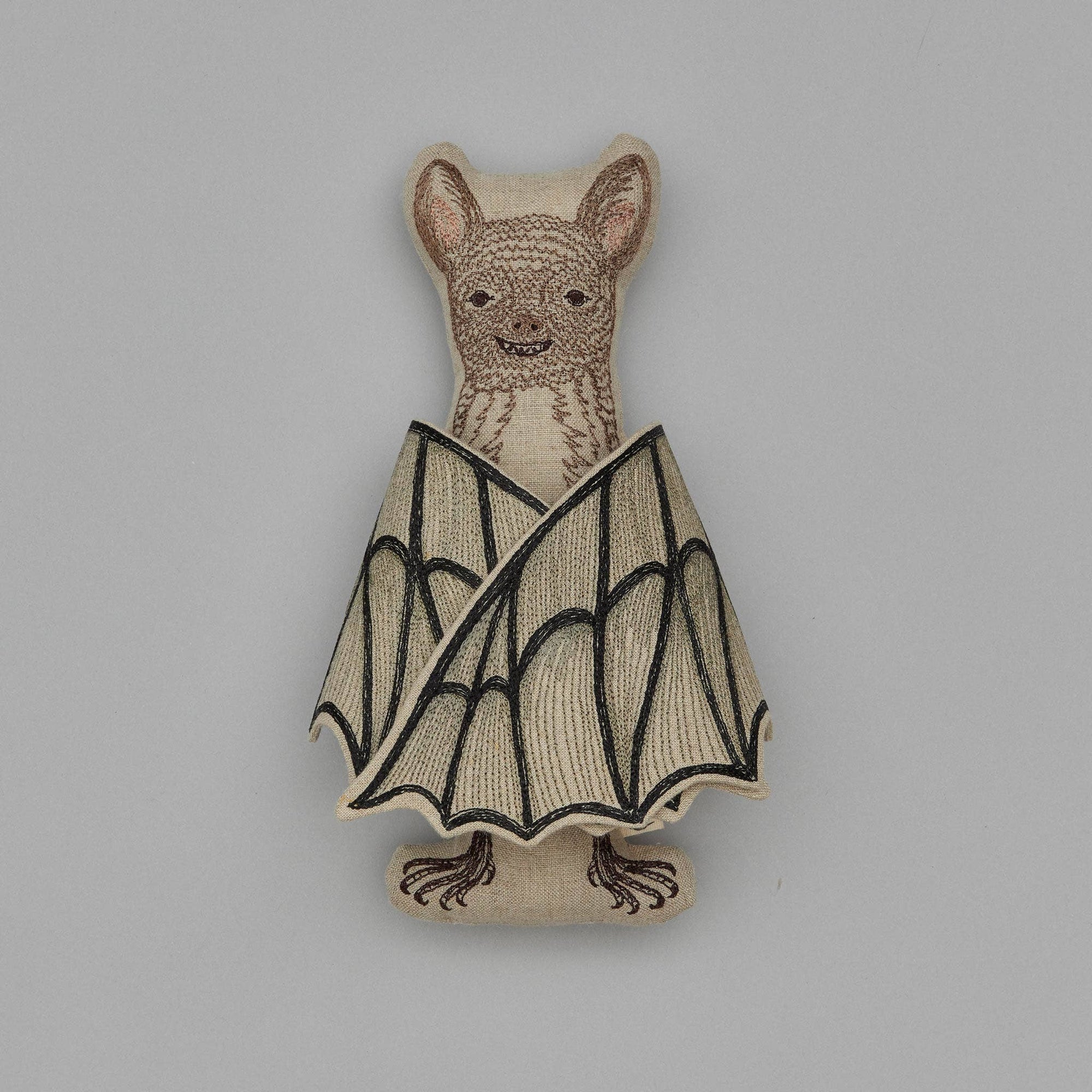 Bat-shaped wooden toy on a gray background